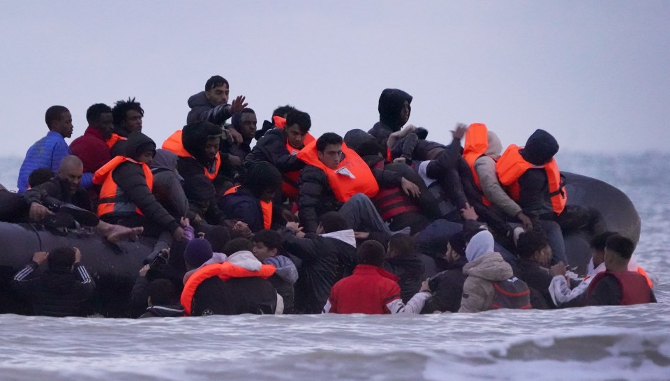 Migrants wading through the sea to board a small boat in Gravelines, France.